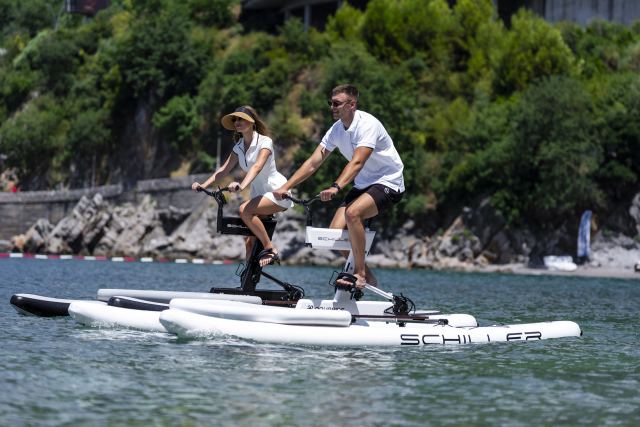 Couple riding waterbikes along the coast